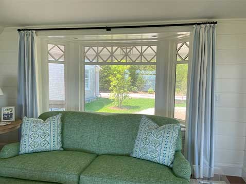 Green couch with drapery behind